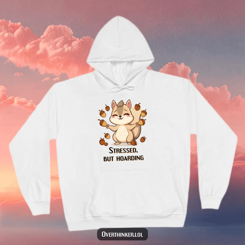 Funny hoodie depicting a smiling but stressed squirrel character juggling many acorns, perfect for those who feel overwhelmed.